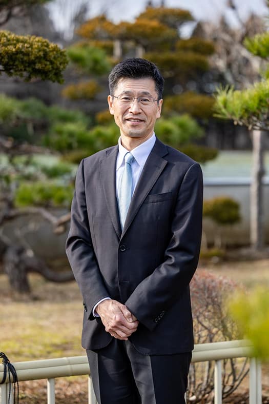 庭園を背景にした成田光寿